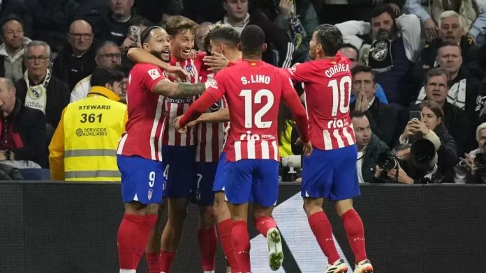 Gelandang Atletico Madrid dan Spanyol Marcos Llorente merayakan setelah mencetak gol pertama timnya selama pertandingan La Liga EA Sports antara Real Madrid dan Atletico Madrid di Stadion Santiago Bernabeu